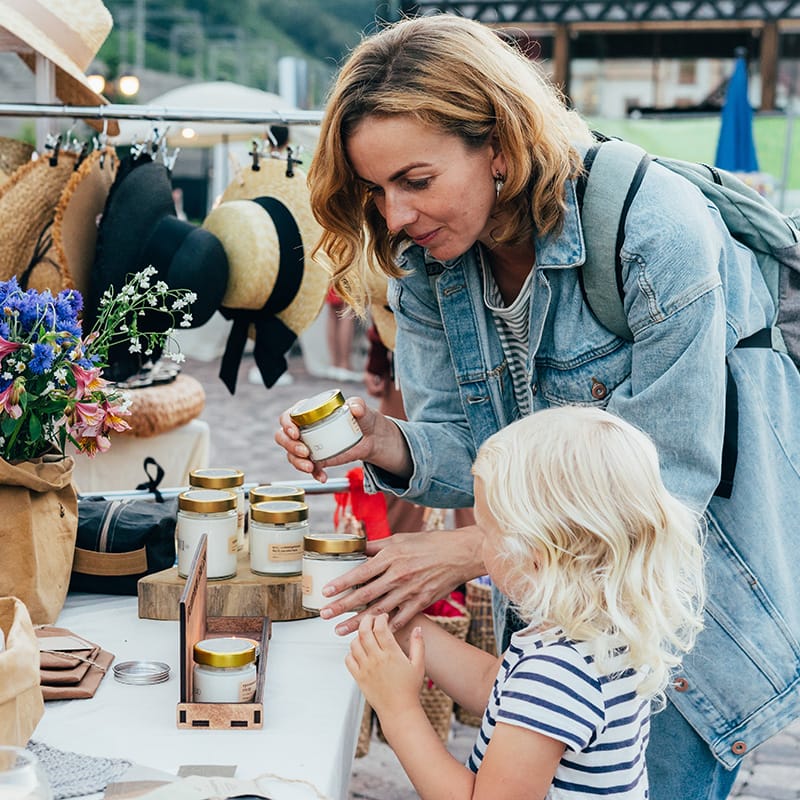 Mother and child exploring a local artisan market, representing Trillium Estates amenities with rich cultural activities and community events.